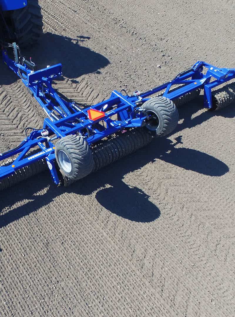 Ein landwirtschaftliches Gerät bearbeitet den Boden auf einem Feld