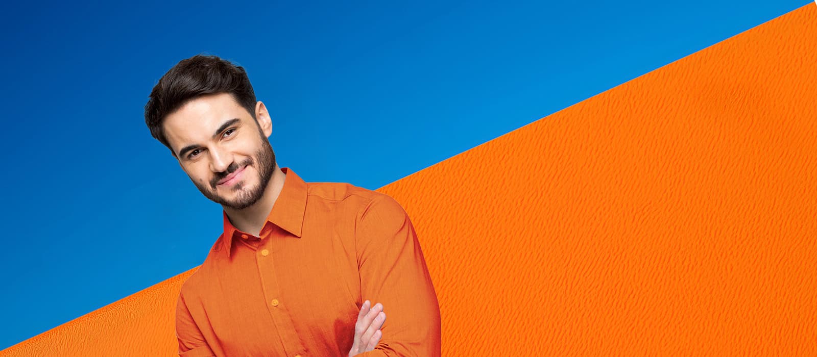 Sympathischer, lächelnder, junger Mann vor einem blau/orangefarbenen Hintergrund