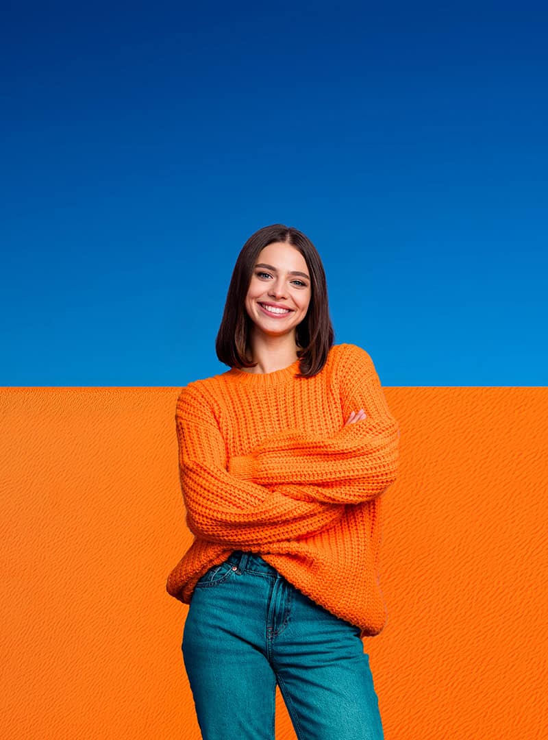 Eine lachende, sympathische, junge Frau mit orange/blauem Hintergrund im Fokus